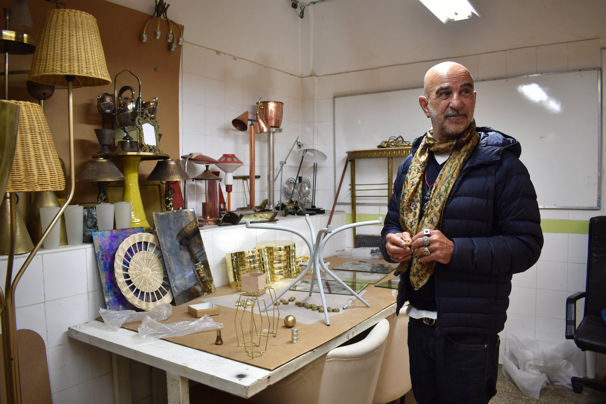 Jonathan Amar standing in a room with various decorative items and lamps.